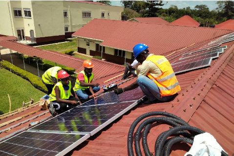 Crew installing solar panels on a hospital roof