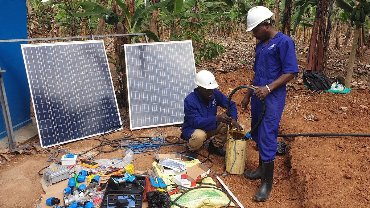 Technicians assembling a solar-powered borehole pump kit