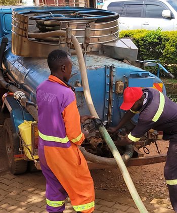 Crew operating a cesspool emptier truck in Kampala