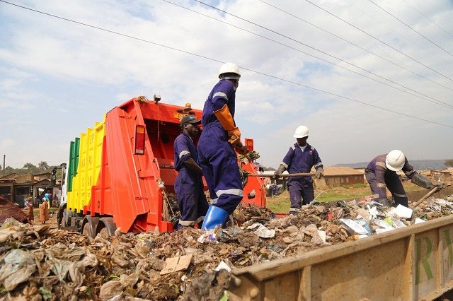 Crew loading a garbage truck during a collection round in Kampala